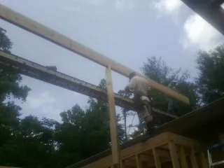 Carpenter setting a ridge beam over a new addition frame — Ice Dam Removal by Roofing Brothers in Longford