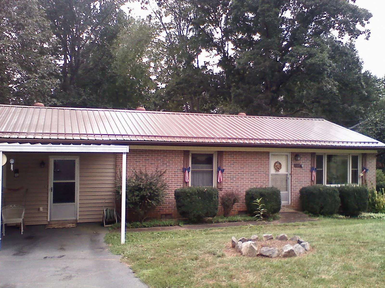 Bronze metal roof and carport on a brick ranch home — Roof Repair work by our crew in Longford
